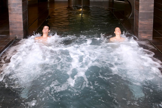 Photo high angle view of young man and woman in swimming pool