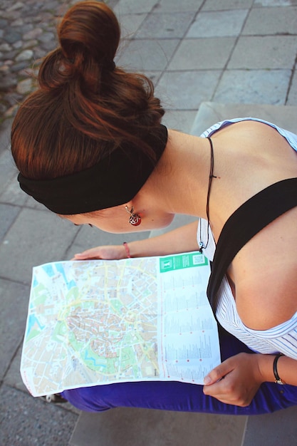 Foto vista ad alto angolo di una giovane donna che guarda la mappa