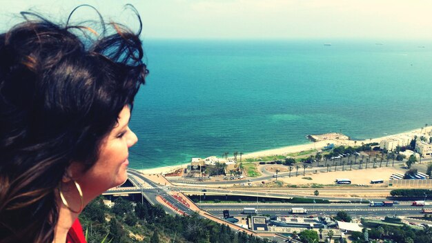 Foto vista ad alto angolo di una giovane donna che guarda il mare