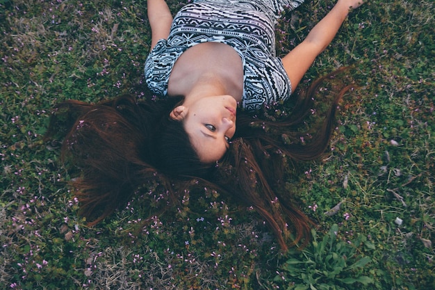 Photo high angle view of young woman lying on grass