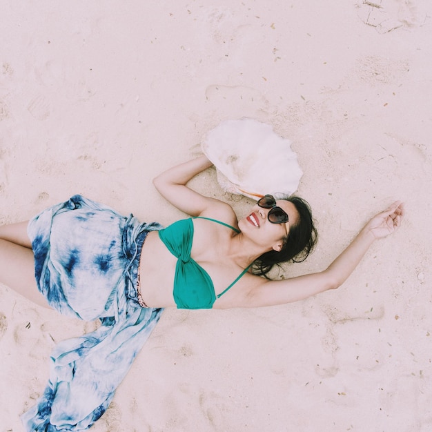 Photo high angle view of young woman lying on sand