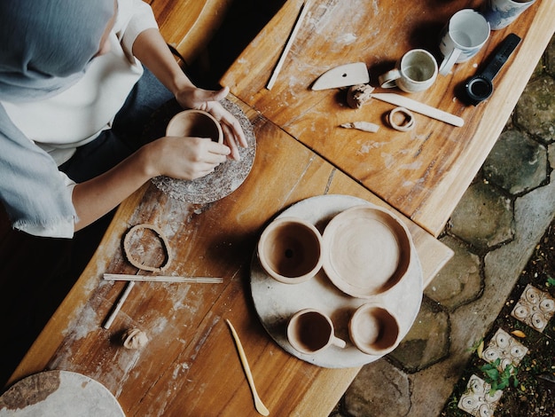 High angle view of young woman making pottery at workshop