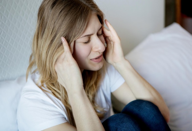 家のベッドに座っている若い女性の高角度の視点