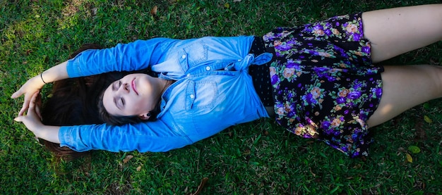 High angle view of young woman sleeping on grassy field