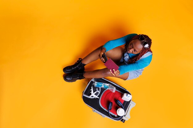 High angle view of young woman standing against yellow background