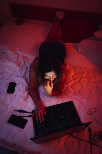 high angle view of young woman using laptop on bed at home