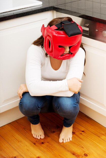 High angle view of young woman wearing sports helmet while crouching on floor at home