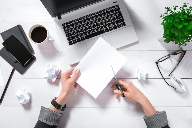 High angle view of an young woman working at her office desk with documents and laptop.