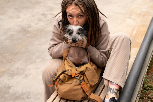 Photo high angle woman carrying puppy in bag