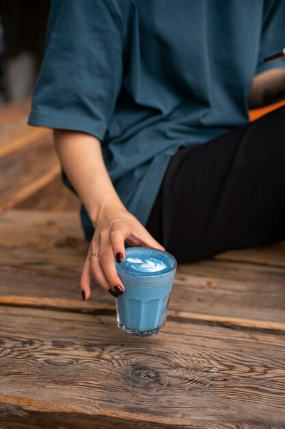 Photo high angle woman enjoying a blue matcha