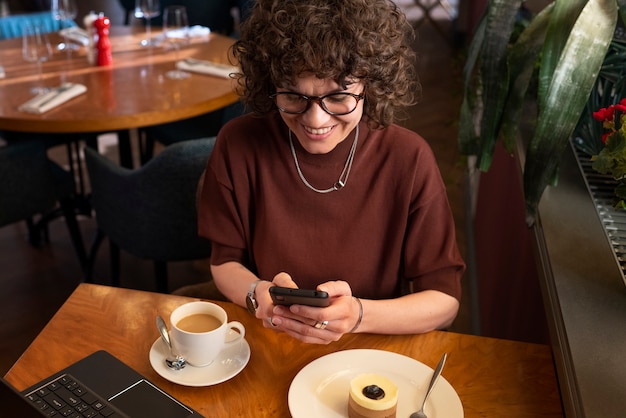 Photo high angle woman holding smartphone