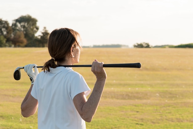 Foto donna dell'angolo alto che gioca a golf