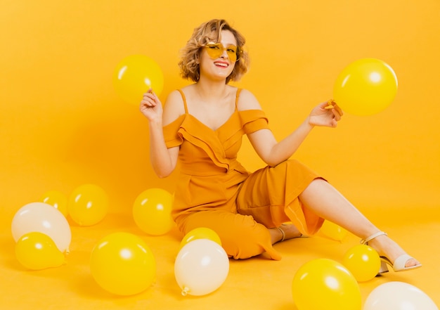 High angle woman playing with balloons