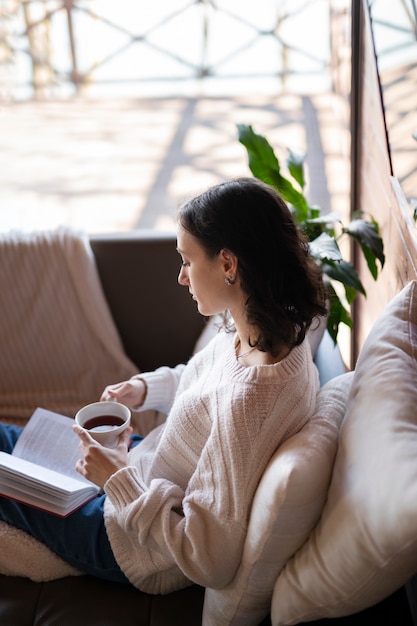 High angle woman reading with coffee cup