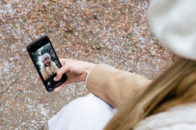 High angle of woman taking selfie in the park during winter