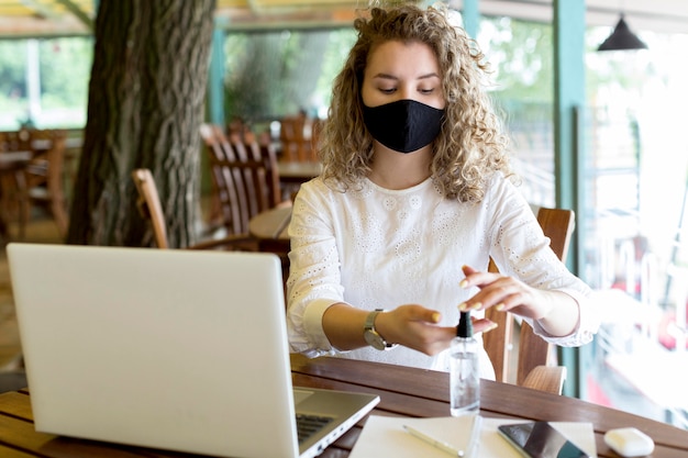 Foto donna ad alto angolo utilizzando disinfettante per le mani