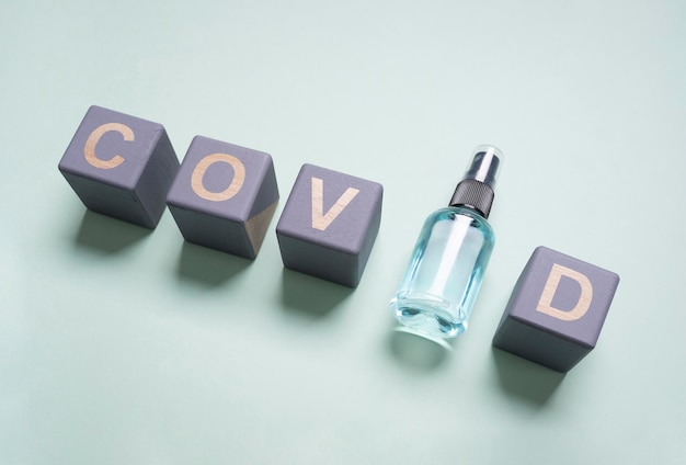 High angle of wooden cubes with covid and hand sanitizer