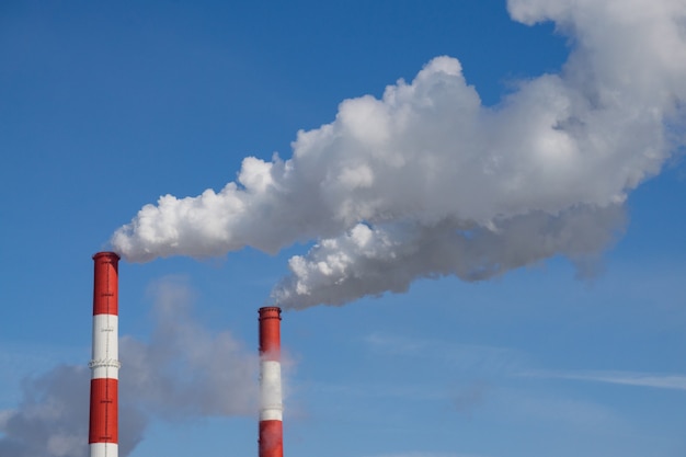 High chimneys of the power station and thick smoke in the sk