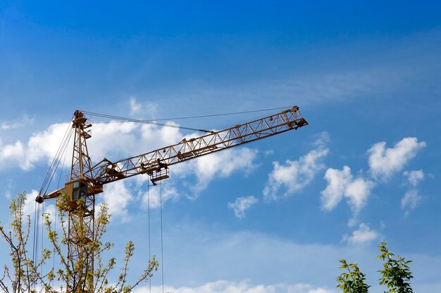 High construction cranes against the blue sky