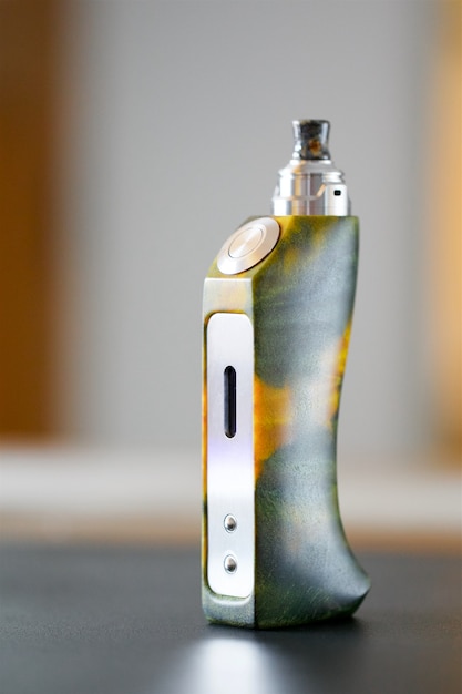 High end yellow green stabilized poplar burl wood box mods with rebuildable dripping atomizer and drip tip, vaping device, vape gear, vaporizer equipment, selective focus