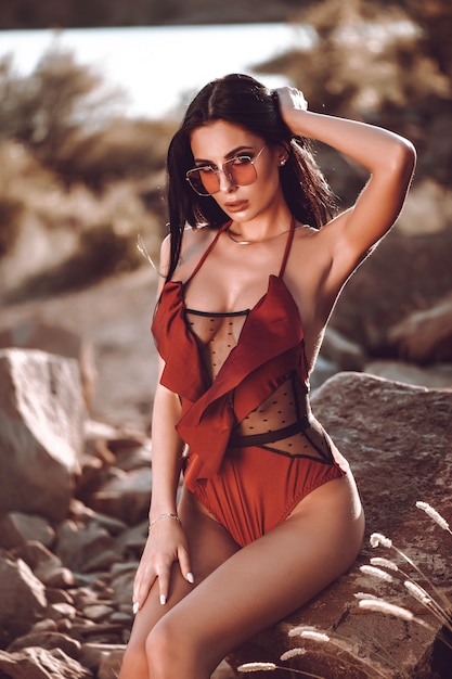 ファッション性の高いlook.glamor美しいセクシーなスタイリッシュな若い女性モデル完璧な日光浴赤い水着できれいな肌。