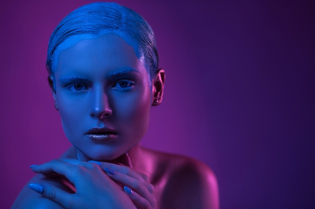 High fashion model in neon verlichting met glitter make-up