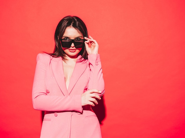 High fashion portrait of young beautiful brunette woman wearing nice pink summer suit