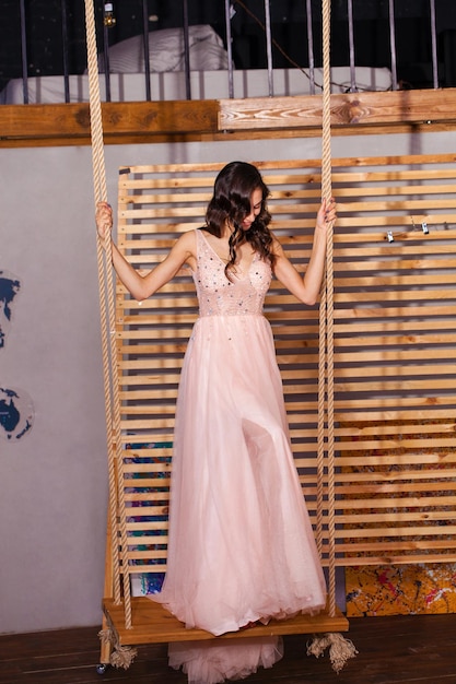 Photo high fashion shot of young brunette woman in pink long dress