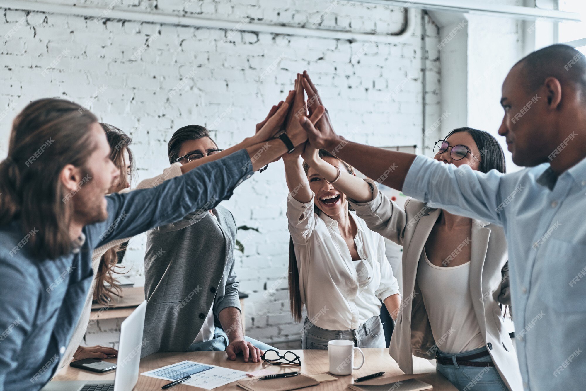 Colleagues Giving High-Five Celebrating Business Success Standing In Office  Stock Photo by ©Milkos 381522740