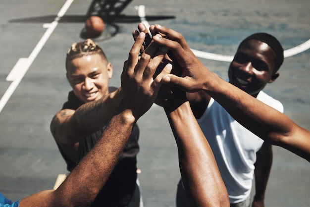 Foto batti cinque lavoro di squadra e basket in primo piano per sostenere la motivazione o la partita sul campo da basket squadra di giocatori di basket e sorridere insieme per il gioco sportivo e il successo per il team building in allenamento