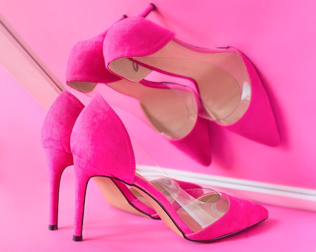 Photo high heels shoes on pink background watching its own reflection in the mirror