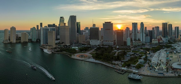 High illuminated skyscrapers of Brickell citys financial center Skyviews Miami Observation Wheel at Bayside Marketplace with reflections in Biscayne Bay water and US urban landscape at sunset