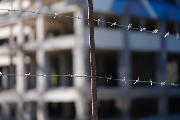 High level barbed wire fence in background of building