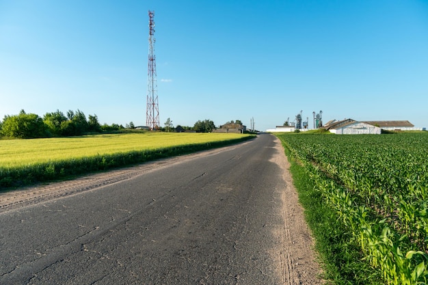 Рядом с проезжей частью установлена высокая современная вышка сотовой связи, передающая радиосигнал 5g и 4g Радиоактивное излучение в сельской местности
