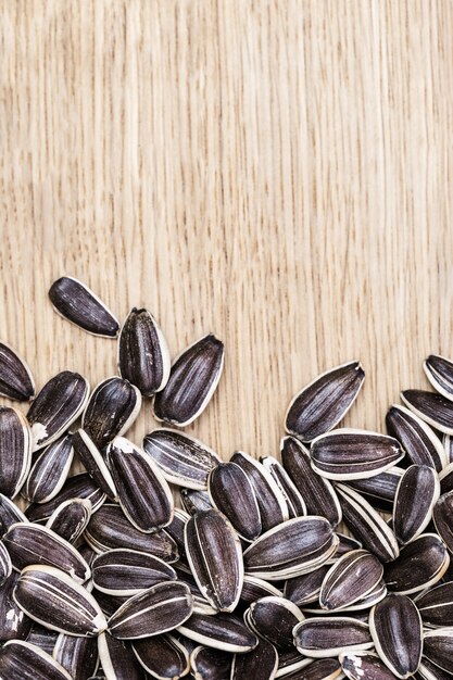 High quality seeds of sunflower on wooden background with copy space. Not peeled seeds. Vertical format.