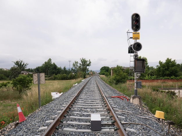 Photo high railway signal for the e2 entrance to the monforte de lemos station indicating a stop red and a yellow sign indicating quotstart maneuvering areaquot next to its associated beacon