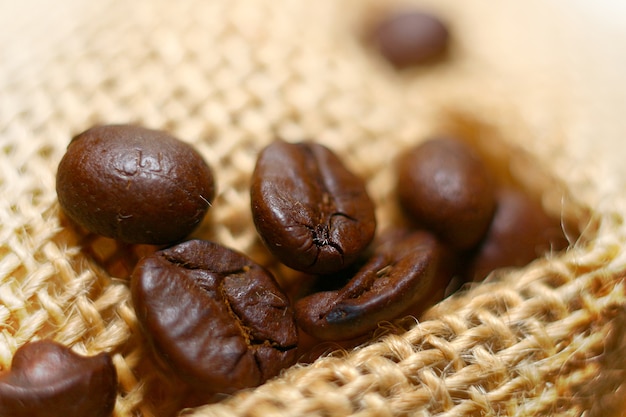 high resolution macro image of dark roasted coffee beans on sack