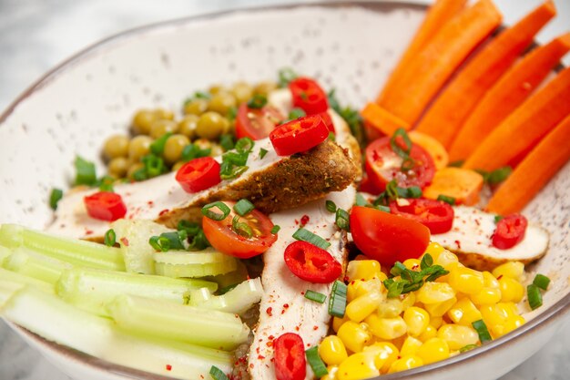 Фотография высокого разрешения вкусного салата с различными ингредиентами на тарелке на белой поверхности со свободным пространством