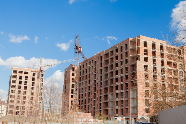 High-rise multi-storey buildings under construction. tower
cranes near building. activity, architecture, development process,
skyscraper.