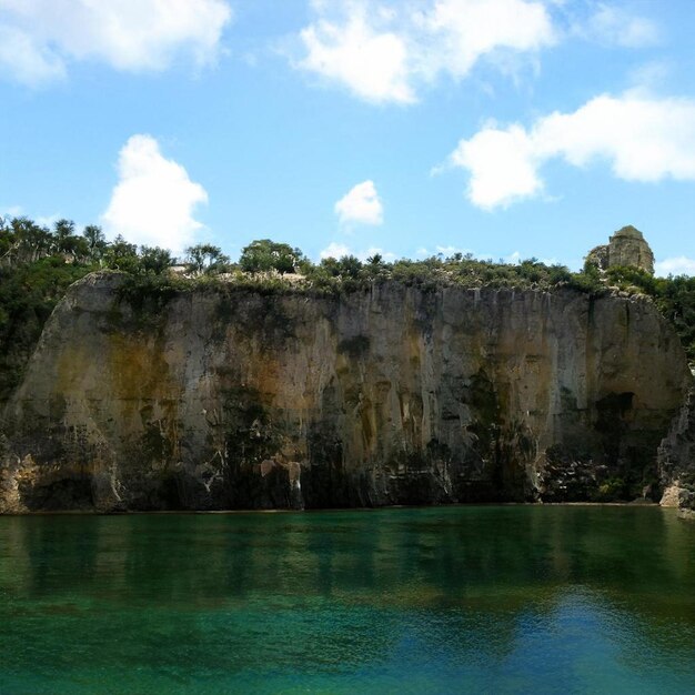 Foto alta parete rocciosa con lago e cielo blu