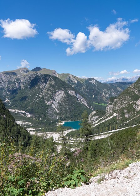 High rocks Alps in Italy South Tyrol Dolomites Green landscape with stones and trees Paths in the mountains Travel Tourist places Beautiful nature Blue clouds