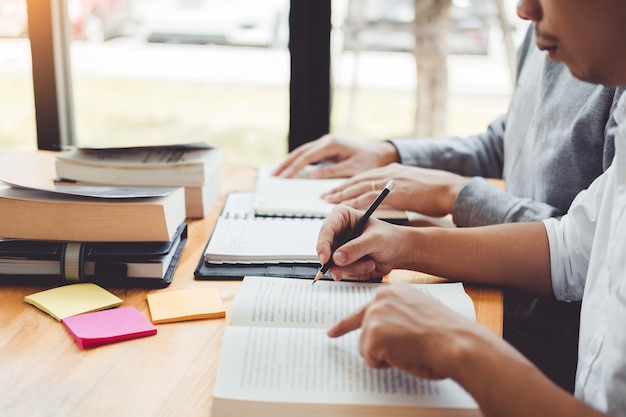 high school or college students studying and reading together in library