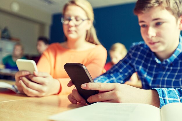 Photo high school students with smartphones texting