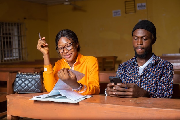 High School Tutor Giving Male Student One To One Tuition At Desk