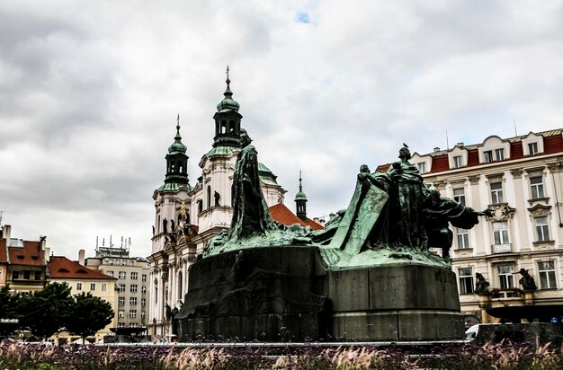 High section of statues on built structure against clouds