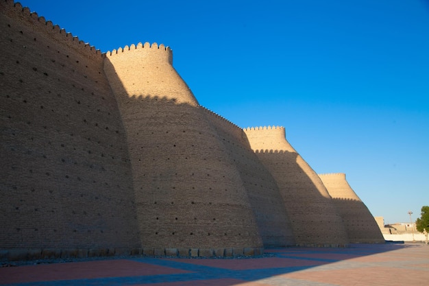 ウズベキスタン観光コンセプトのブハラにあるアーク要塞の高い堅固なレンガの壁