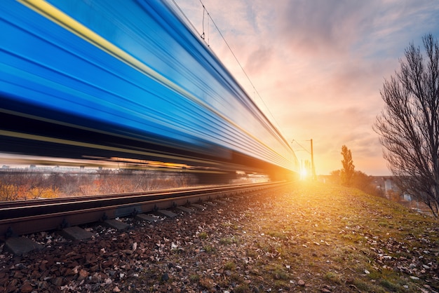 Photo high speed blue passenger train on railroad track in motion