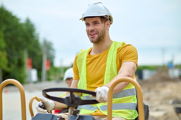 high-spirited skilled operator driving an earth rammer machine