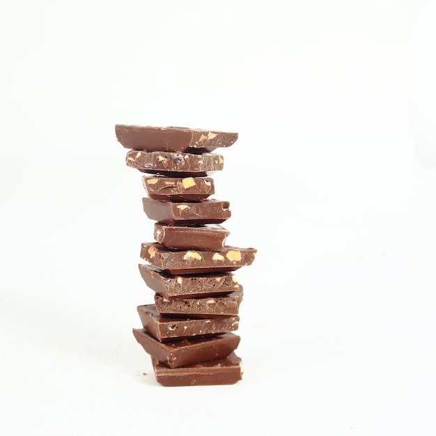 High stack of slices of original milk chocolate isolated on whi