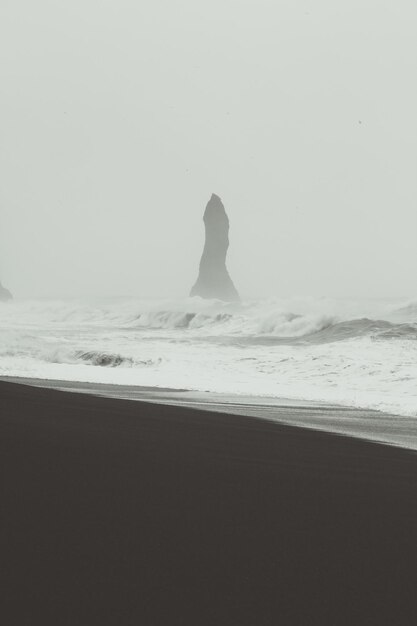 High stone in stormy sea monochrome landscape photo